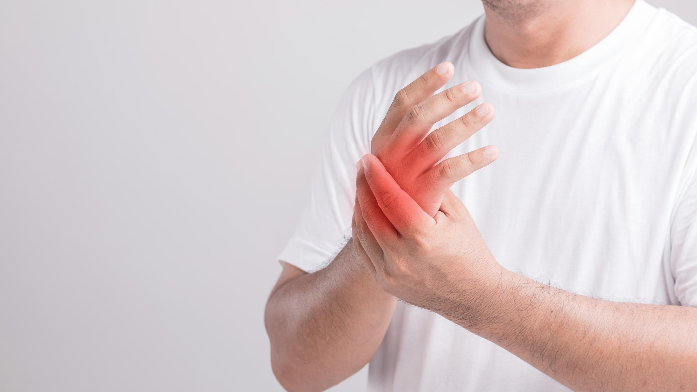 Close up man touching palm and feeling a pain. Studio shot isola